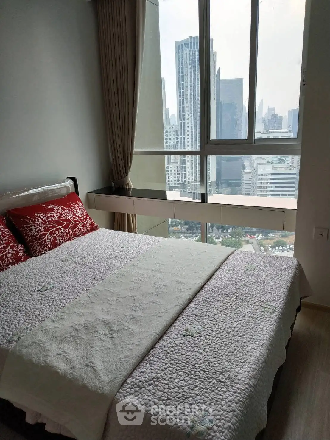 Cozy bedroom with city view and elegant decor in high-rise apartment
