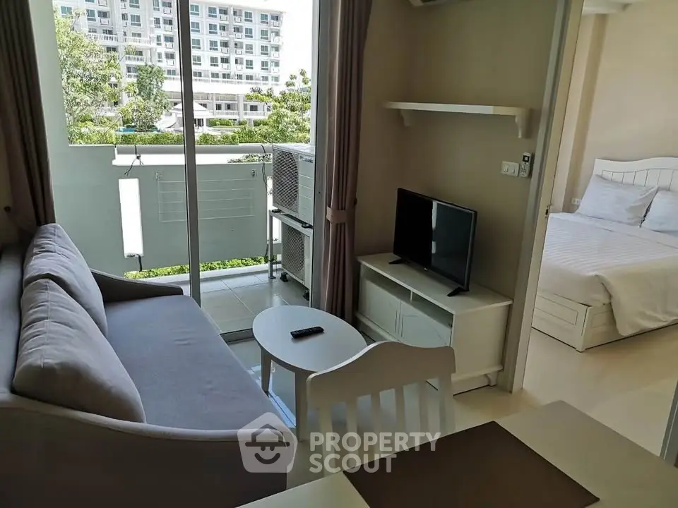 Modern apartment with cozy living room and bedroom, featuring a balcony with a view.