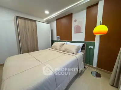 Cozy bedroom with modern decor and warm lighting, featuring a comfortable bed and stylish wardrobe.