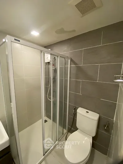 Modern bathroom with sleek shower enclosure and contemporary tile design.