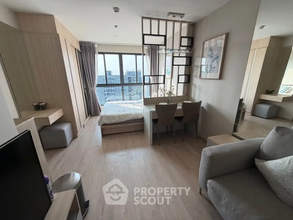 Modern studio apartment with stylish decor and large windows offering city views.