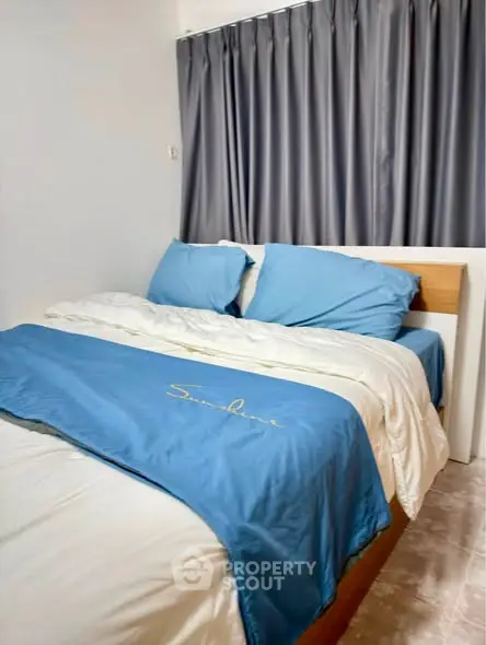 Cozy bedroom with blue bedding and elegant curtains, perfect for restful nights.