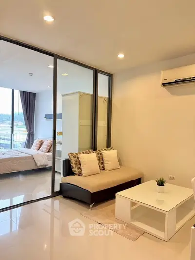 Modern living room with glass partition and cozy bedroom view