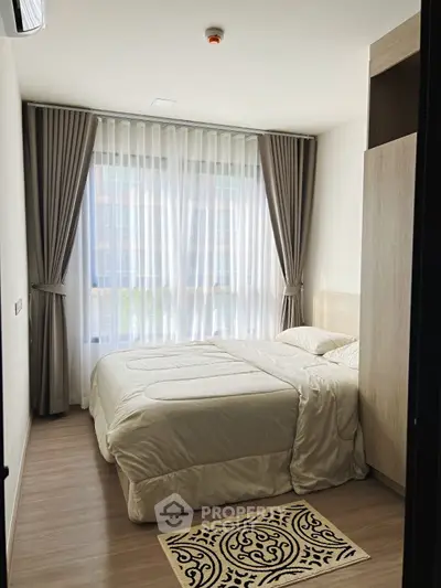 Cozy bedroom with large window and elegant curtains in modern apartment.