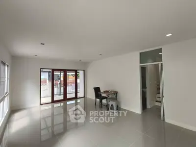 Spacious modern living room with large windows and glossy tiled floor