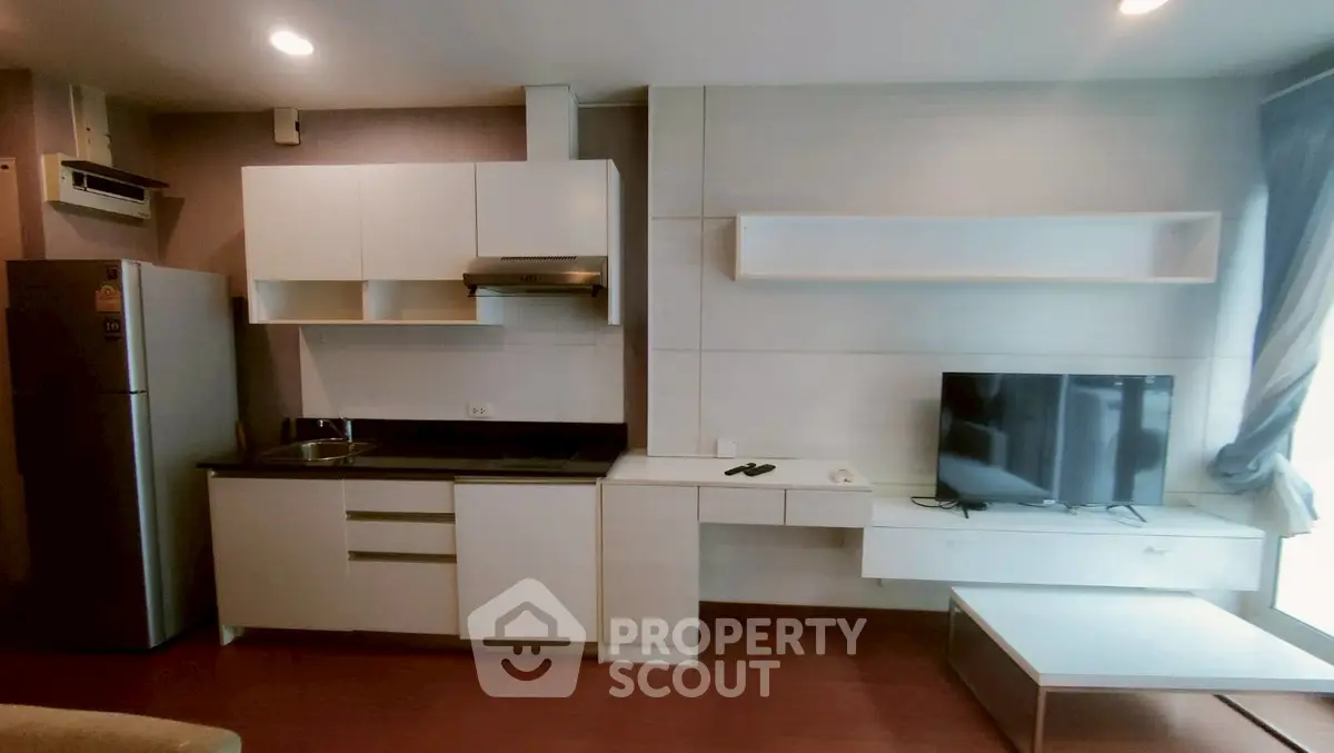Modern kitchen and living area with sleek cabinetry and natural light