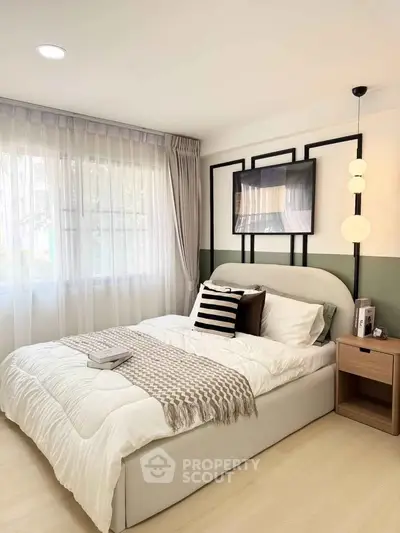 Cozy bedroom with modern decor, large window, and stylish lighting in a serene real estate property.