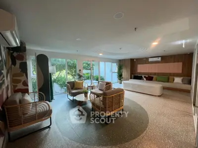 Spacious modern living room with stylish furniture and large windows overlooking a lush garden.