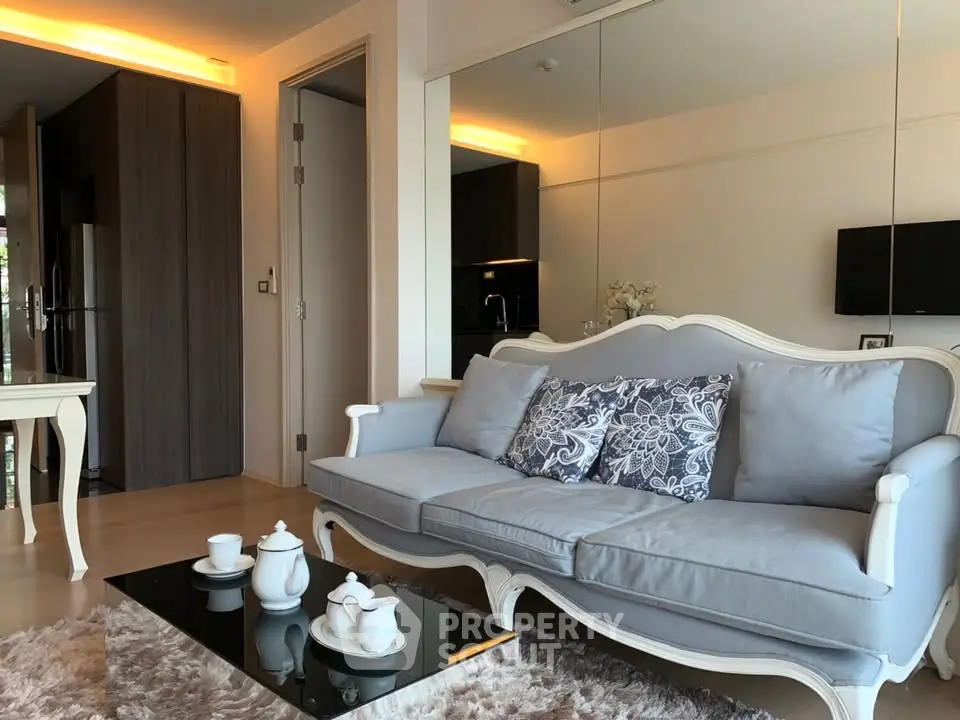 Elegant living room with classic sofa, glass coffee table, and cozy lighting in modern apartment.