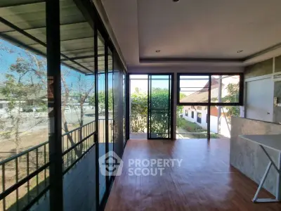 Spacious sunlit balcony with modern glass enclosure and scenic views