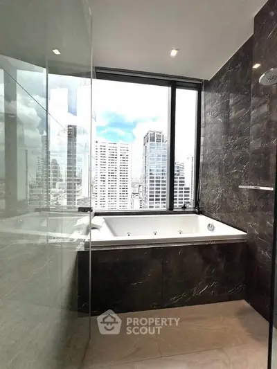 Luxurious bathroom with city view and elegant bathtub in high-rise apartment.