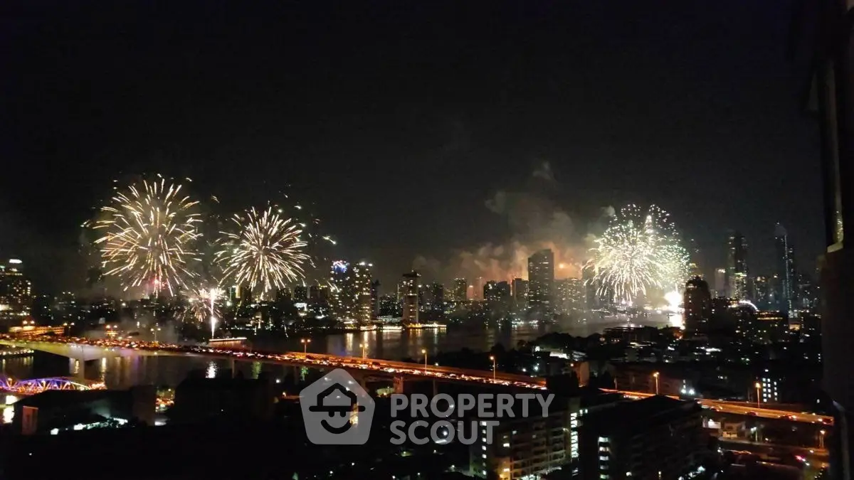 Stunning city skyline view with vibrant fireworks display over a river at night.