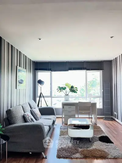 Stylish modern living room with large windows and chic decor, perfect for urban living.