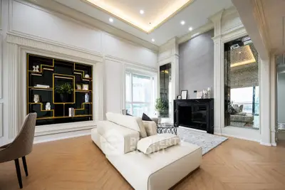 Luxurious modern living room with elegant decor and large windows offering natural light.