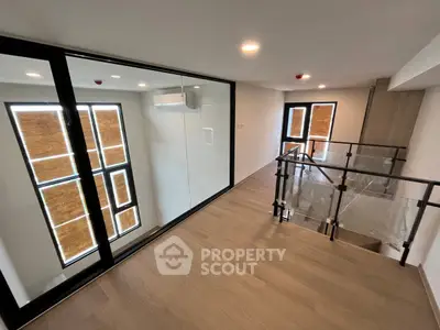 Modern duplex interior with glass railing and large windows