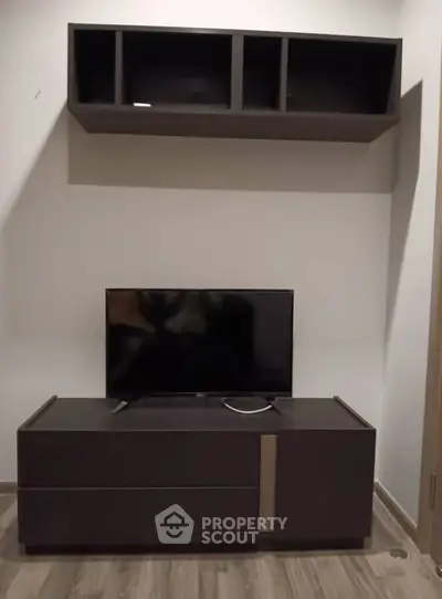 Modern living room setup with sleek TV stand and wall-mounted shelves.