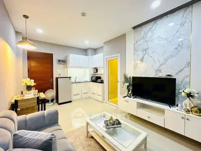 Modern living room with open kitchen, stylish decor, and marble accent wall