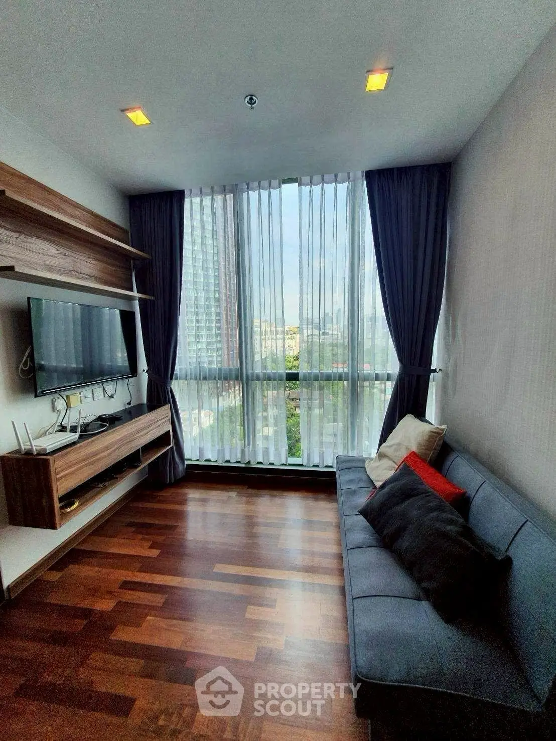 Modern living room with large window and stylish wooden floor