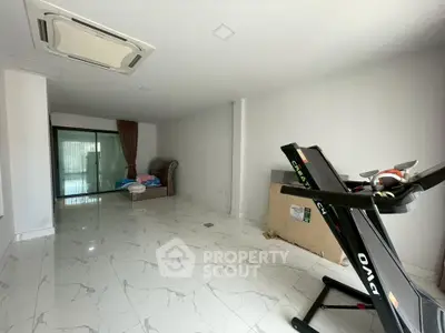 Spacious living room with modern treadmill and elegant marble flooring