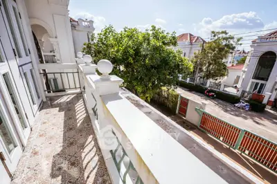 Charming balcony with elegant railing and lush garden view in a luxurious residential area.