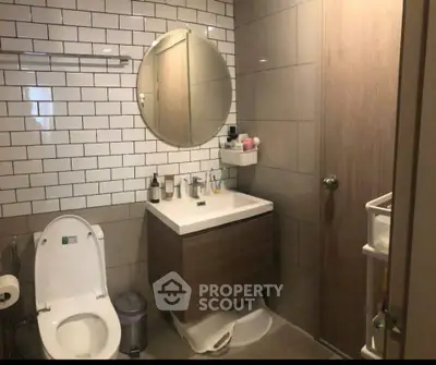 Modern bathroom with round mirror and stylish vanity in contemporary home.
