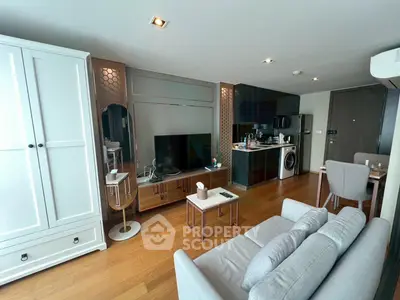 Modern living room with stylish furniture and open kitchen layout in a cozy apartment.