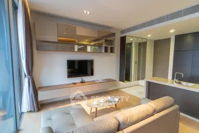 Modern living room with sleek furniture and open kitchen layout in a stylish apartment.