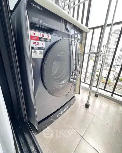 Modern Toshiba washing machine on a balcony with city view, perfect for urban living convenience.