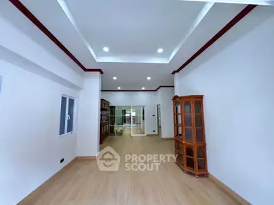 Spacious living room with elegant wooden flooring and built-in shelving, perfect for modern living.