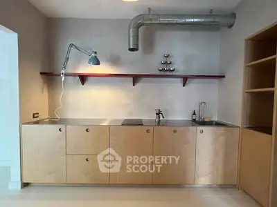 Modern minimalist kitchen with sleek cabinetry and industrial lighting