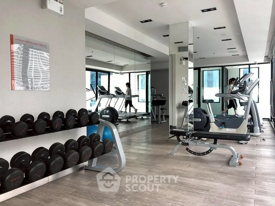 Modern gym with state-of-the-art equipment and mirrored walls in a luxury apartment building.