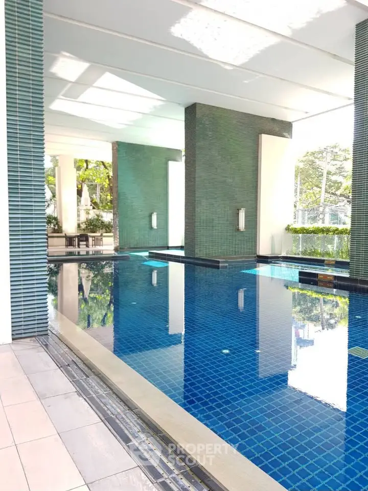 Luxurious indoor pool with modern design and natural light, perfect for relaxation and leisure.