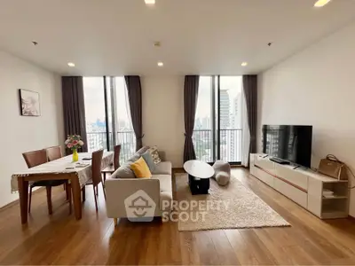 Spacious modern living room with city view, elegant decor, and natural light.