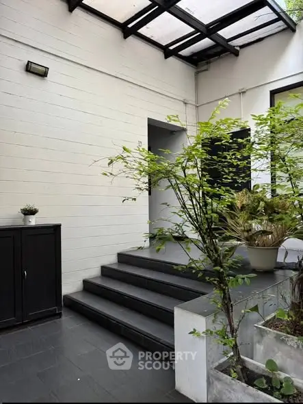 Charming entrance with modern steps and lush greenery