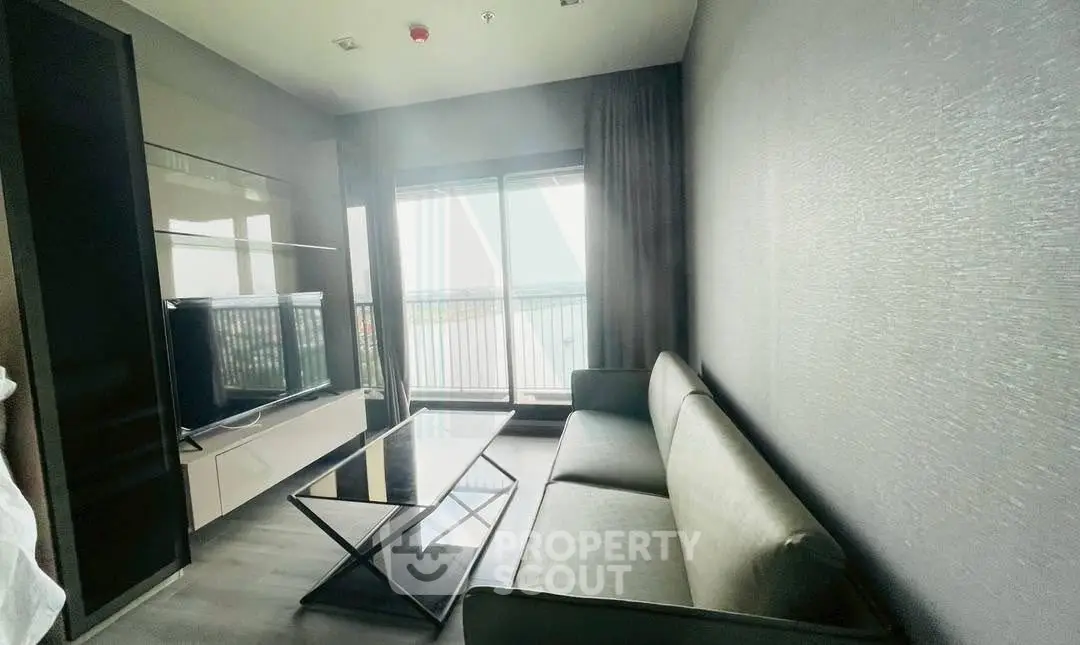 Modern living room with sleek furniture and large window offering a stunning view.