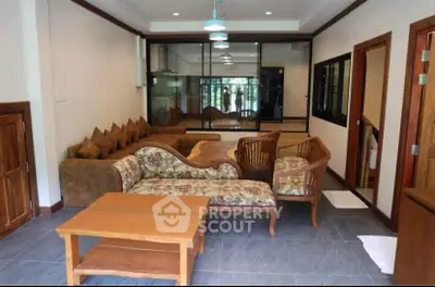 Spacious living room with elegant wooden furniture and large glass windows