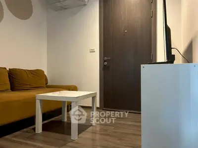 Cozy living room with modern sofa and sleek wooden door, perfect for urban living.