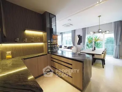 Luxurious open-layout kitchen and living room with modern design and elegant lighting.