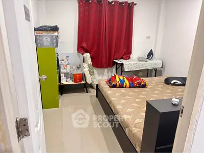 Cozy bedroom with modern furnishings and vibrant red curtains, perfect for comfortable living.