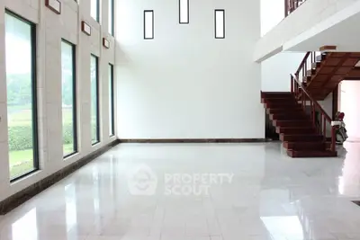 Spacious modern interior with large windows and elegant staircase