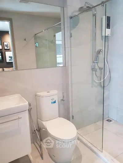 Modern bathroom with glass shower and sleek fixtures in a contemporary home.
