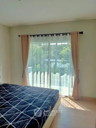 Bright bedroom with large window and modern decor