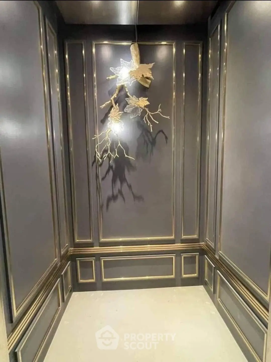 Luxurious elevator interior with elegant paneling and unique lighting fixture.
