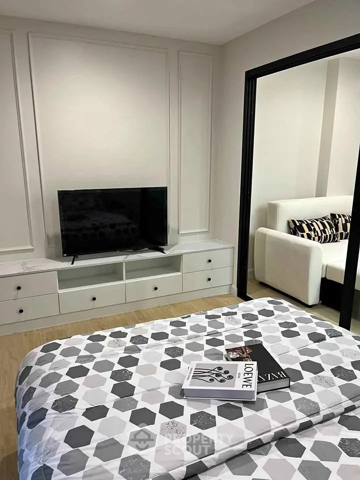 Modern bedroom with stylish decor and TV, featuring a cozy bed and elegant furniture.