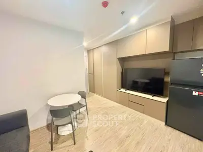 Modern living room with sleek cabinetry and flat-screen TV, featuring a cozy dining area and contemporary design.