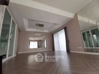 Spacious modern living room with elegant flooring and mirrored wall accents