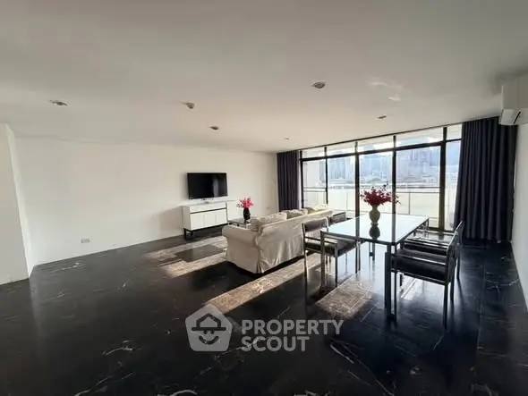 Spacious modern living room with large windows and city view, featuring sleek black flooring and elegant furniture.