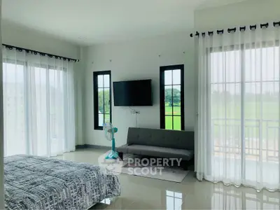 Spacious bedroom with modern amenities, glossy tiled flooring, and large windows offering ample natural light and serene views.