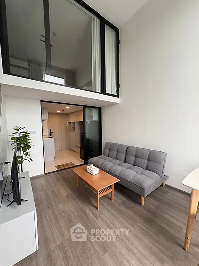 Modern loft-style living room with high ceilings and sleek furnishings