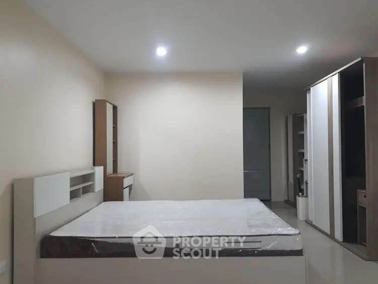 Spacious bedroom with modern furniture and ample storage space